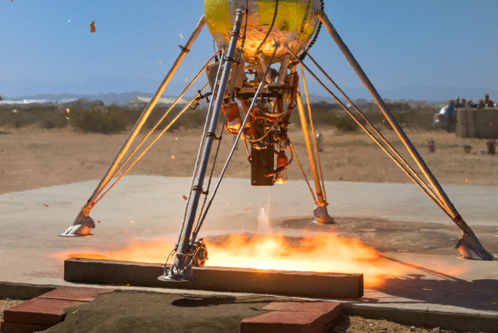 Close up of Astrobotic's Xodiac VTVL launching off of a lunar launch pad in Mojave, CA